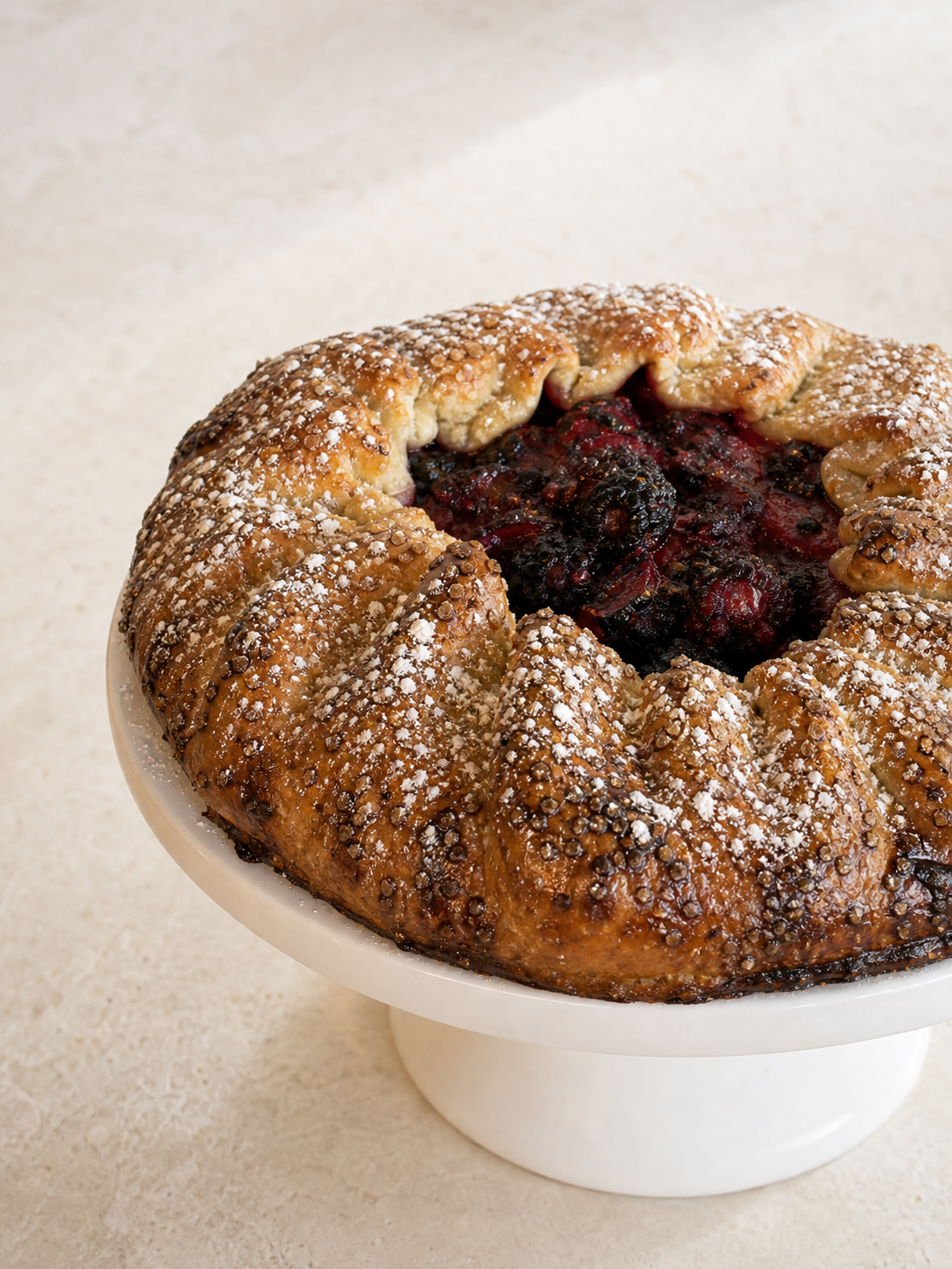 Berry galette with golden pastry crust and powdered sugar